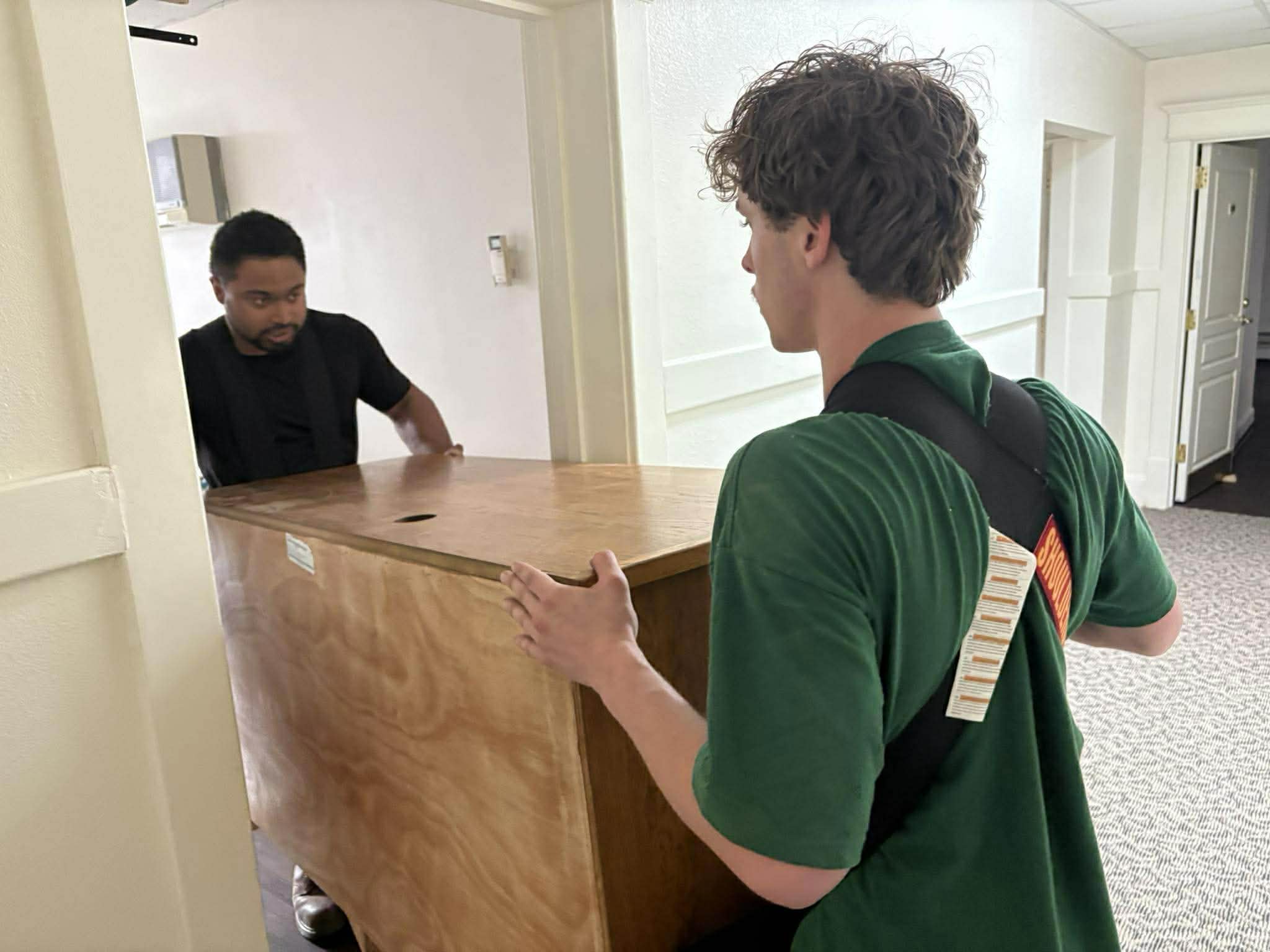 Dakota Moving crew carrying a dresser through a Fargo apartment hallway